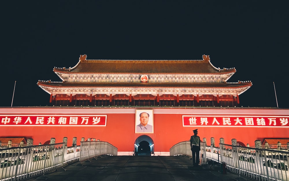 people walking in front of red and white building during nighttime