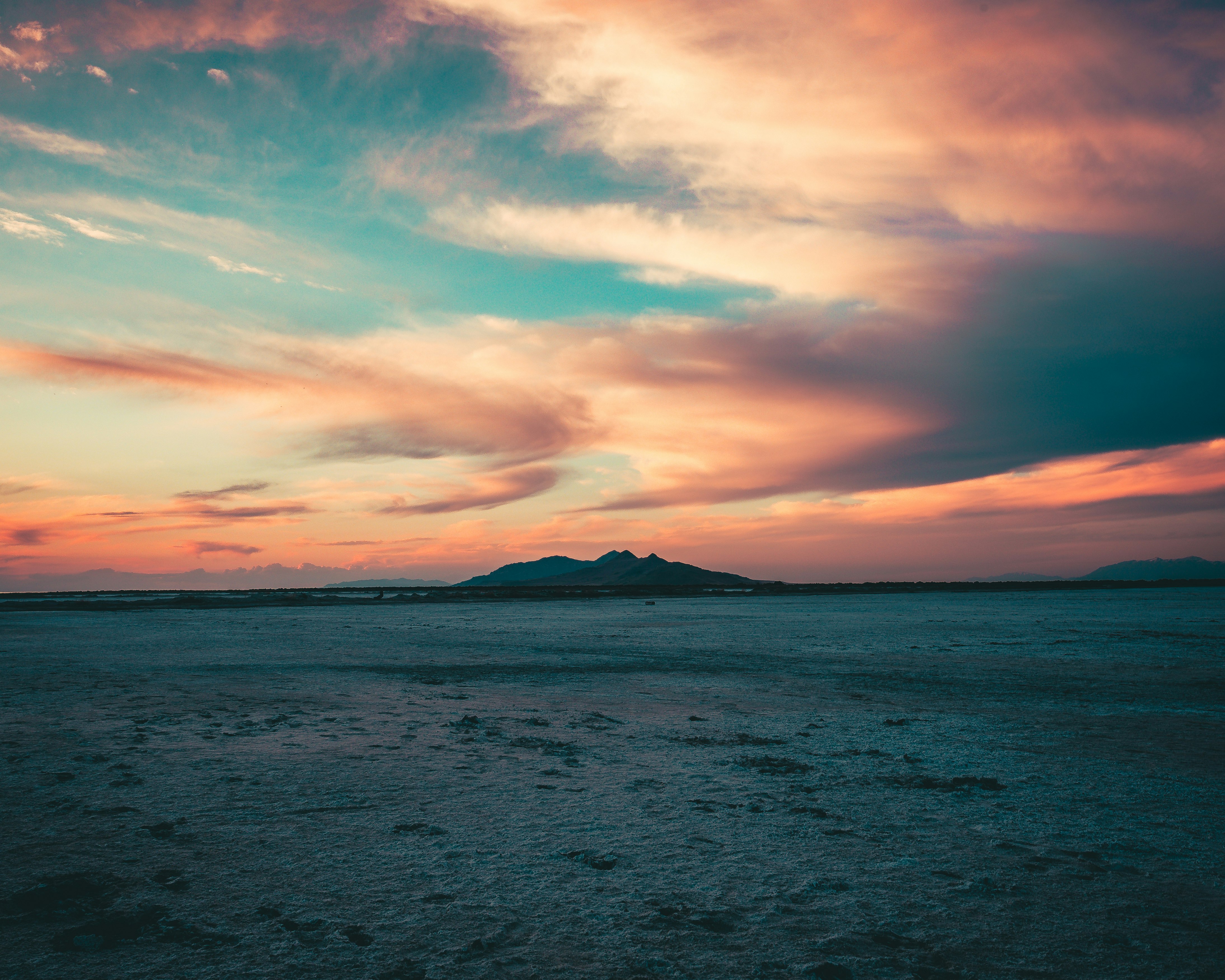 body of water under cloudy sky during sunset