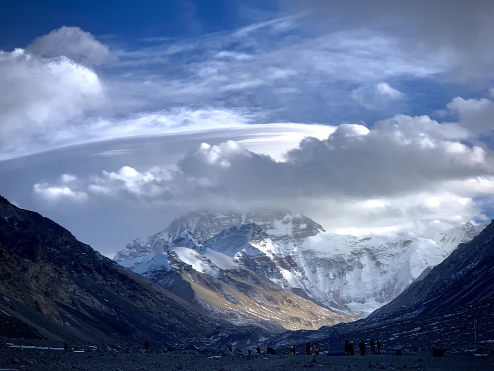 white clouds over snow covered mountains