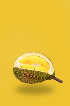 green and yellow fruit with brown stick