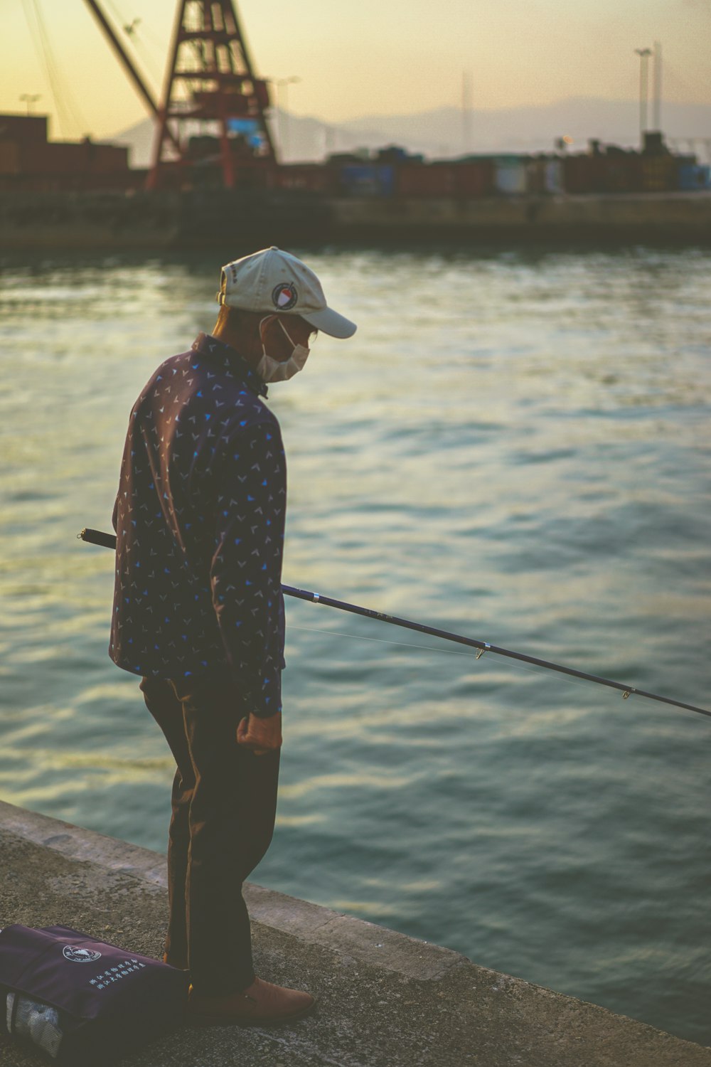 woman in black and red long sleeve shirt and black pants holding black fishing rod