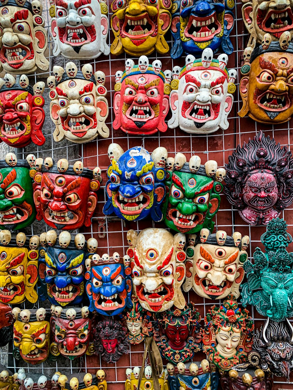 a bunch of masks are hanging on a wall