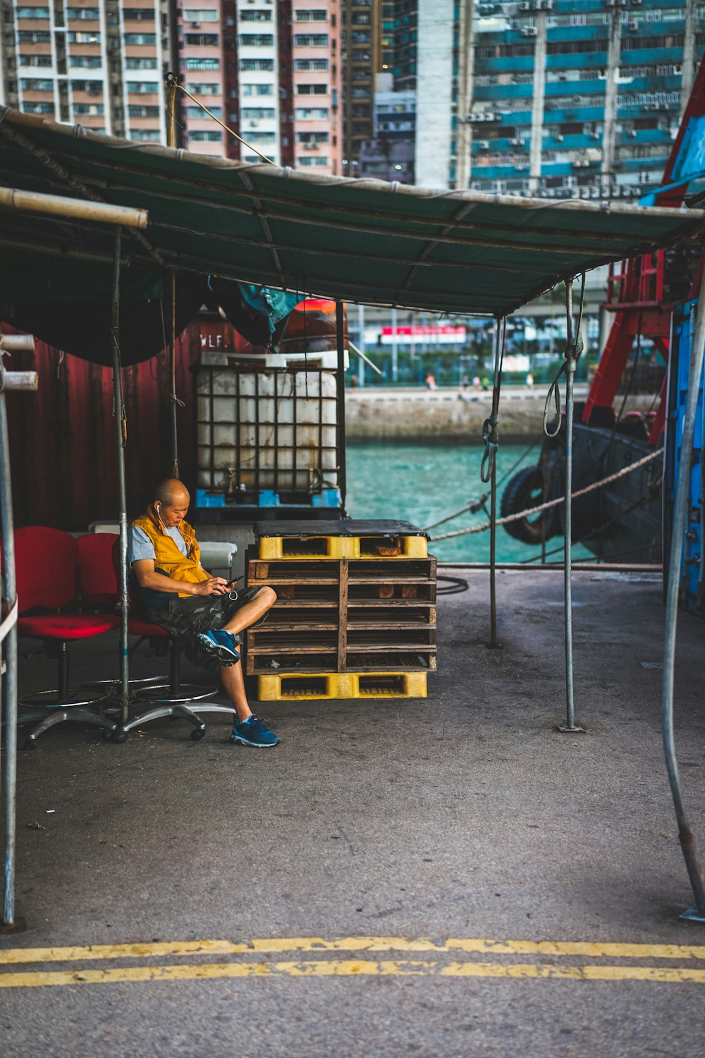 man in blue t-shirt sitting on red and black chair