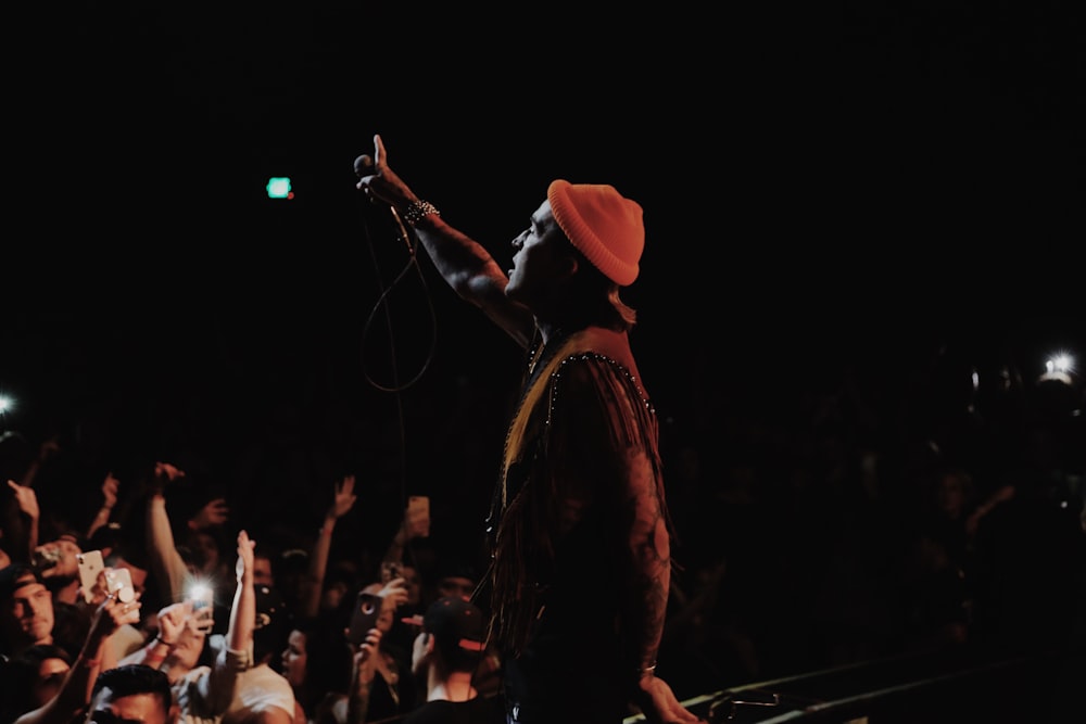 man in black jacket singing on stage