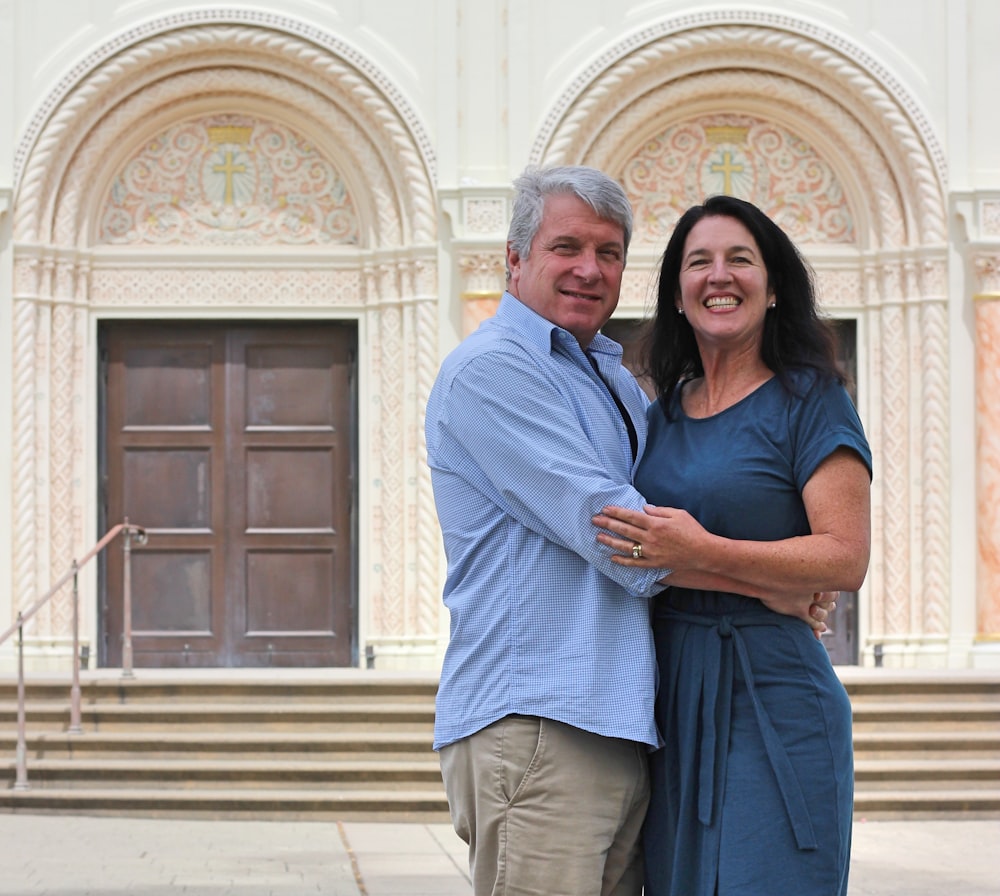 man in blue polo shirt hugging woman in blue long sleeve shirt