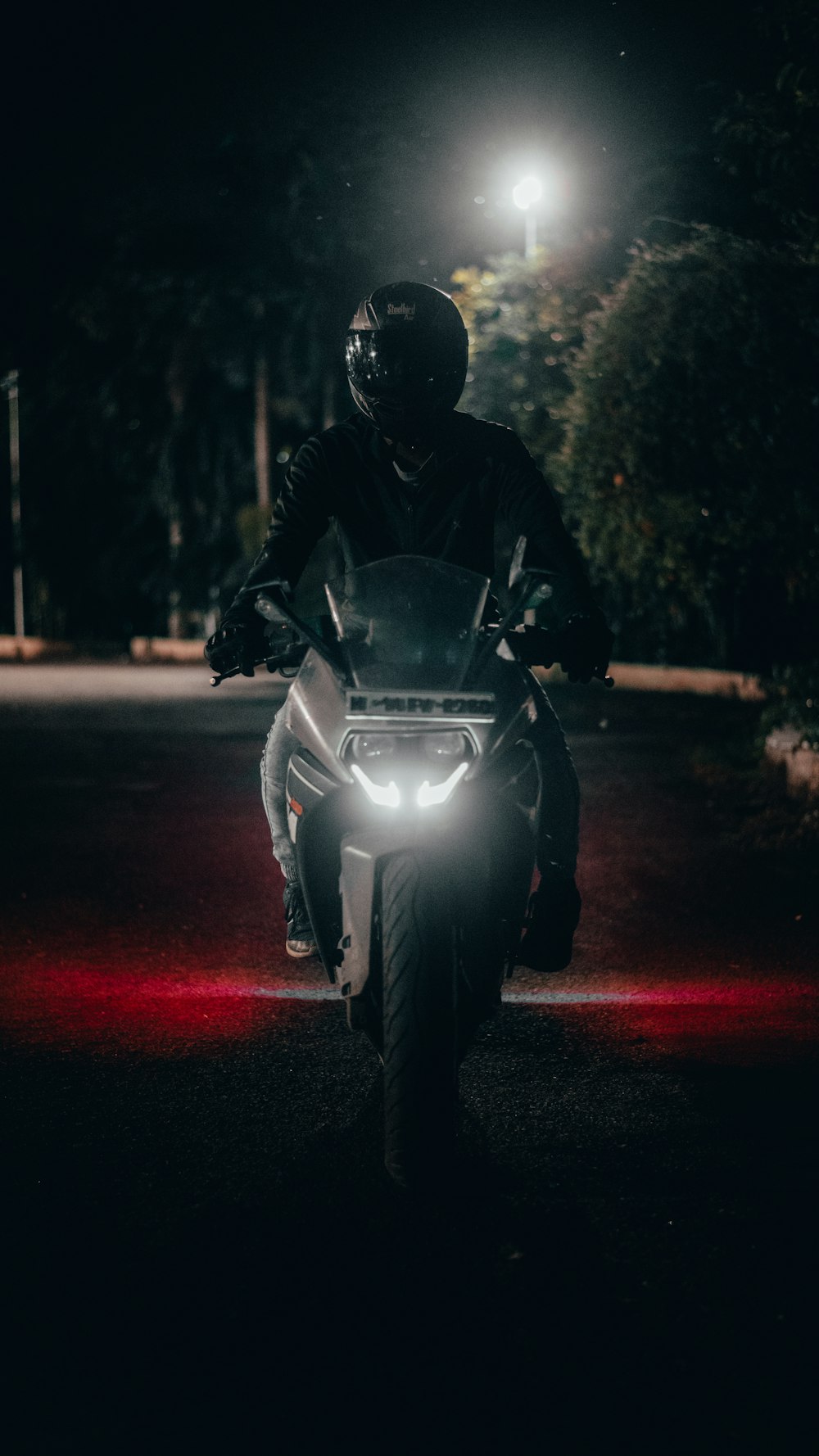 homme en veste noire à moto pendant la nuit