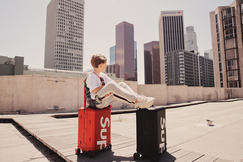 woman in white long sleeve shirt sitting on gray concrete bench during daytime