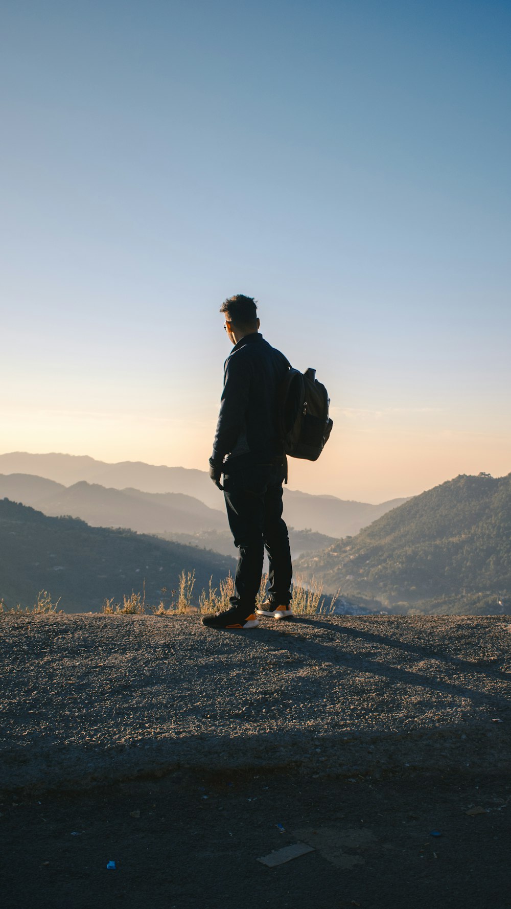 man in black jacket standing on top of mountain during daytime