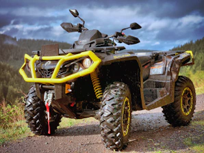 yellow and black atv on brown dirt ground during daytime