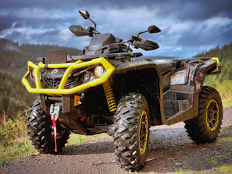 yellow and black atv on brown dirt ground during daytime