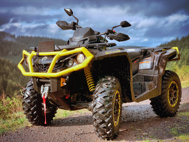 yellow and black atv on brown dirt ground during daytime