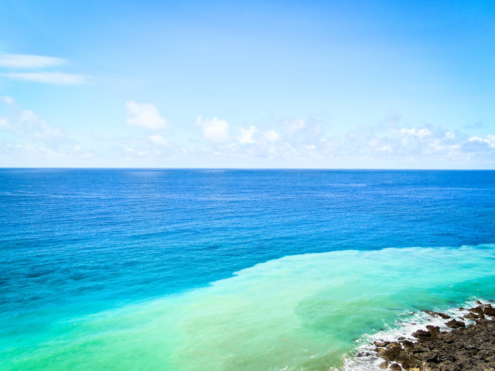 Eau de l’océan vert et bleu sous le ciel bleu pendant la journée