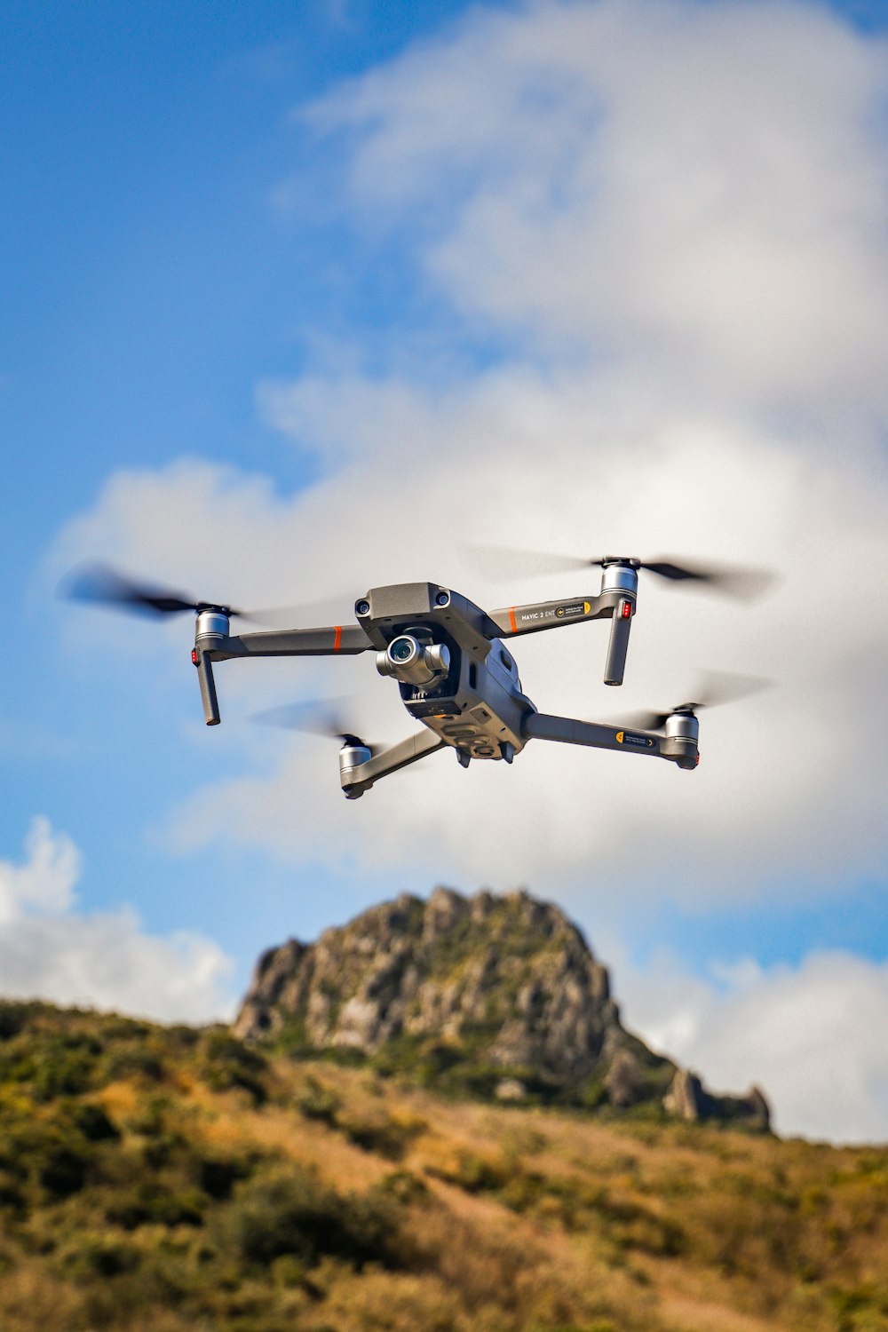 black and white drone flying in mid air during daytime