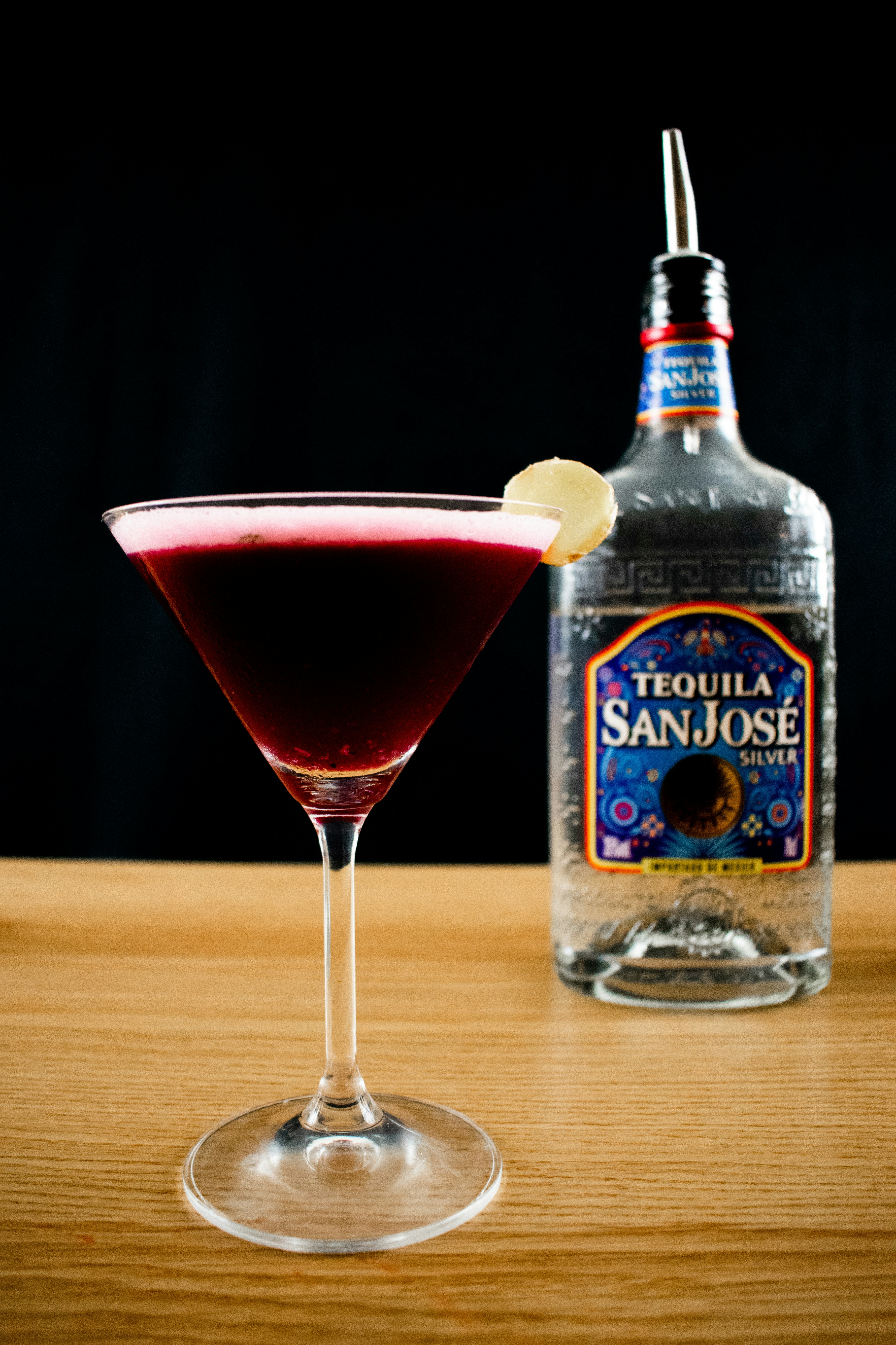 Bouteille d’origine UNK à côté d’un verre transparent avec un liquide rouge