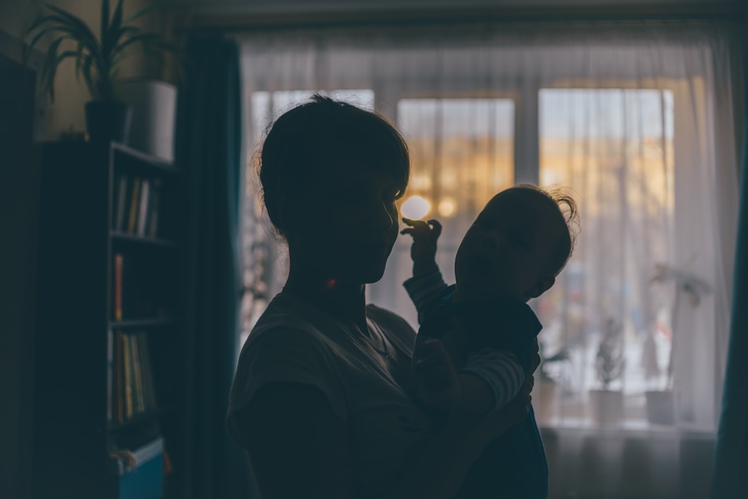 silhouette of woman in front of window during daytime