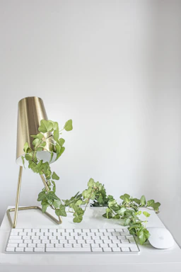 A sleek, modern office desk with a gold pen, ivory stationery, and a softly glowing lamp.