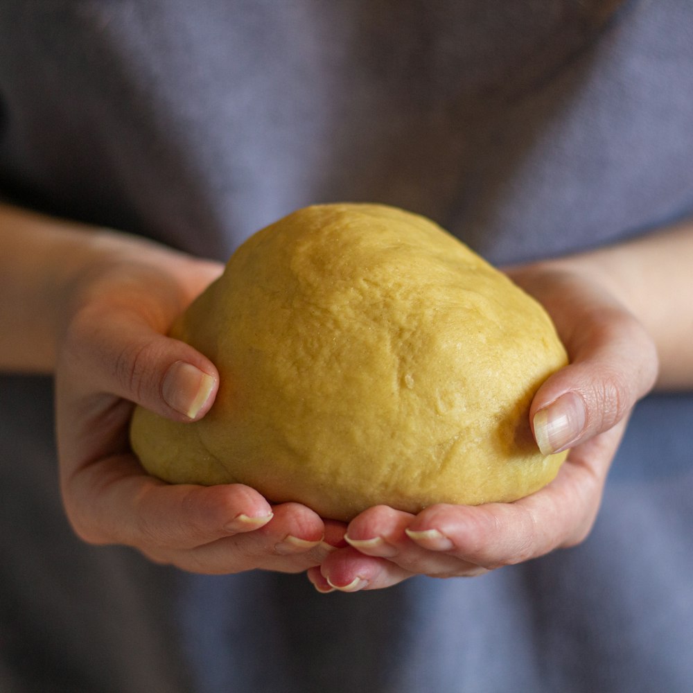 person holding yellow round fruit