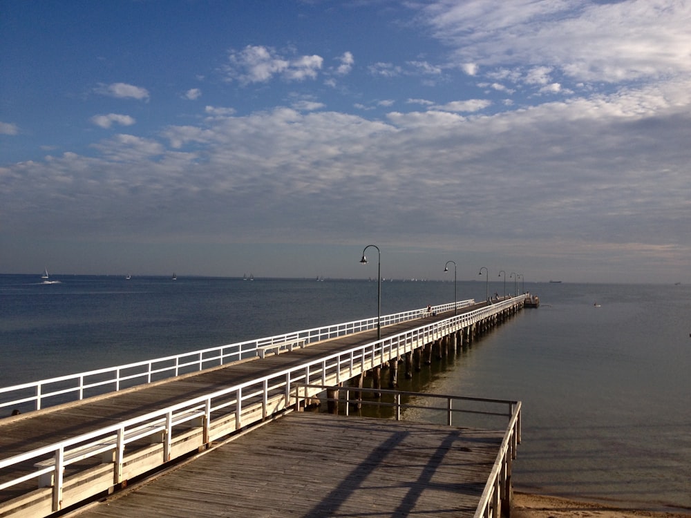 Quai en bois brun sur la mer sous le ciel bleu pendant la journée