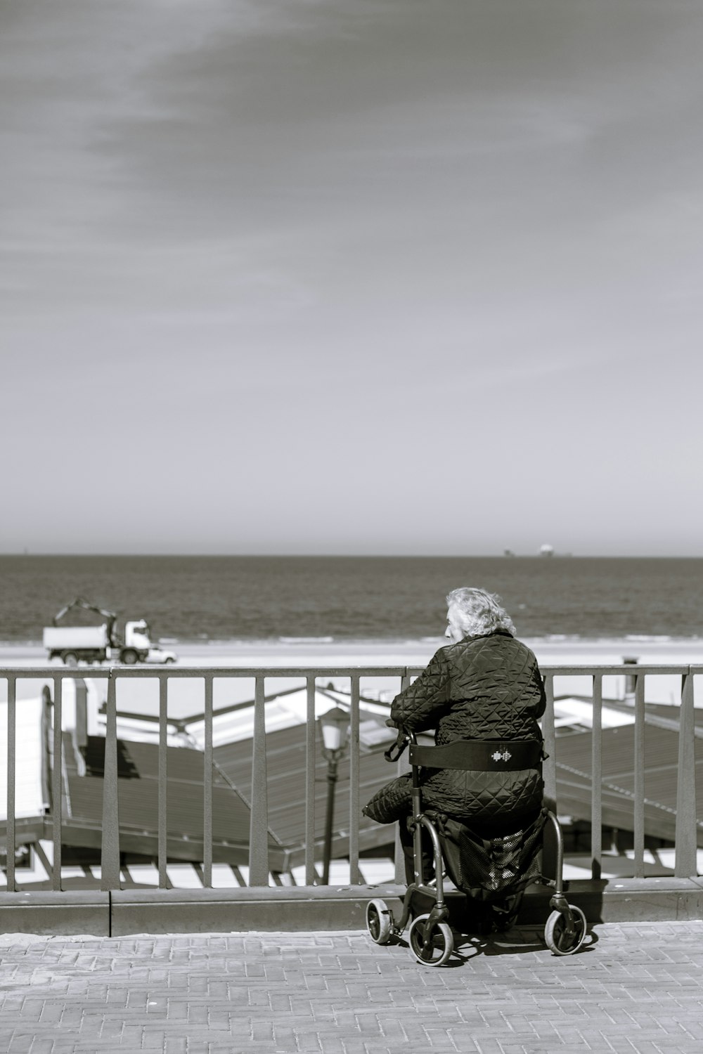 person in black jacket and black pants sitting on black chair