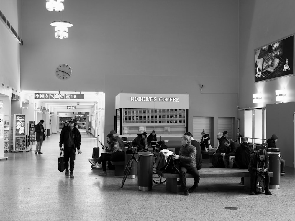 people sitting on chair in grayscale photography