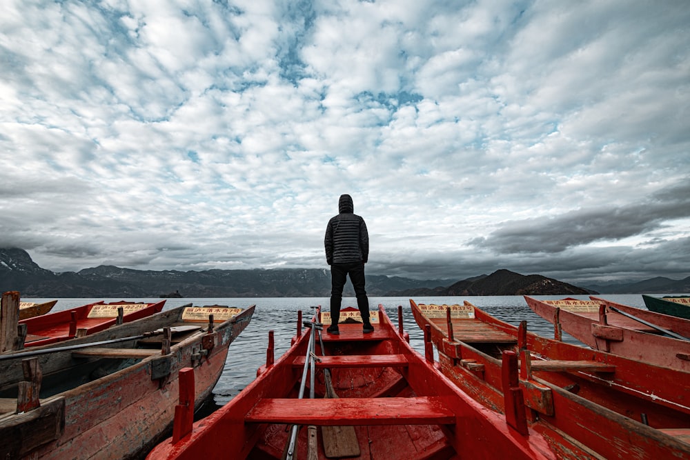 man in black jacket standing on dock during daytime