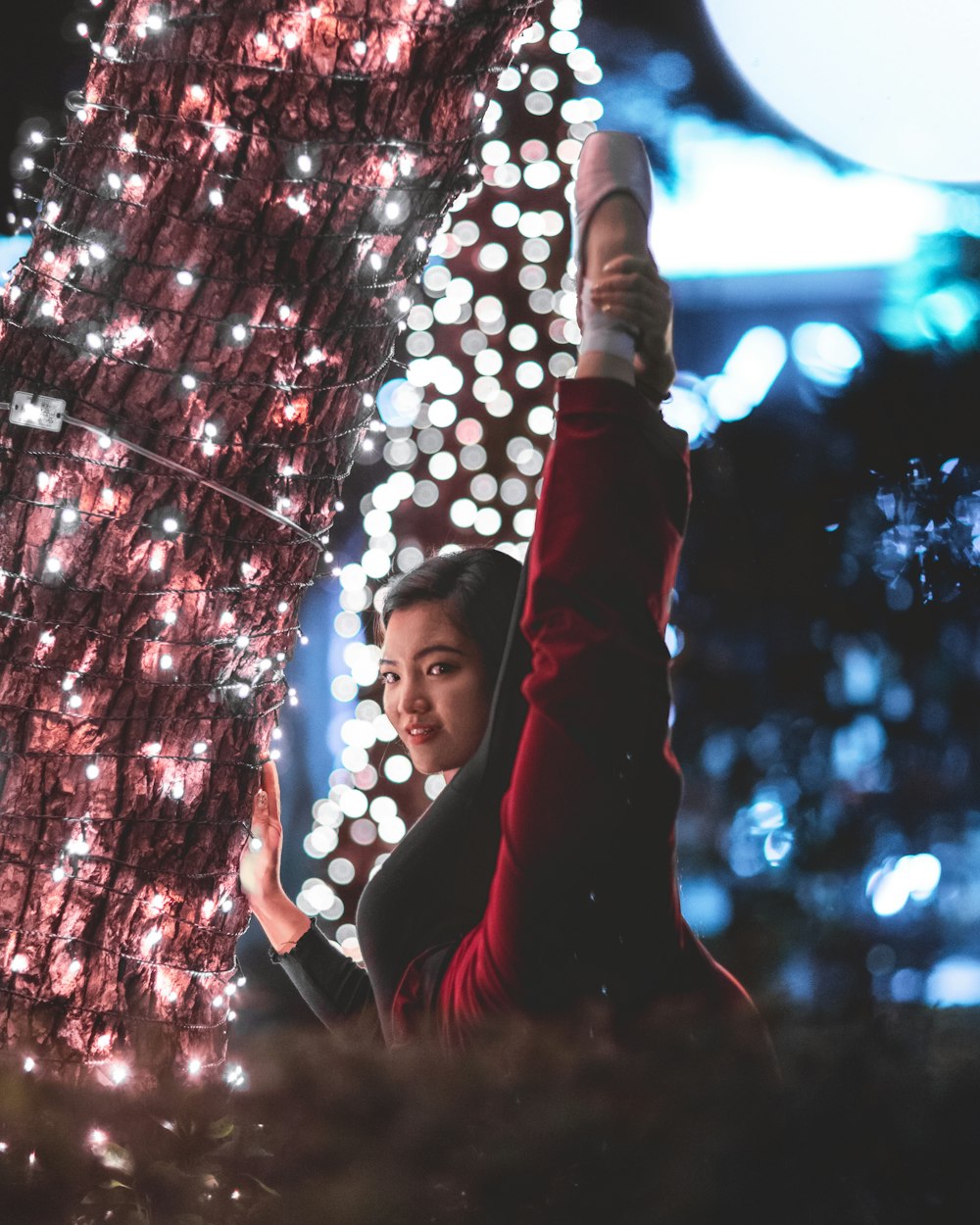 woman in black long sleeve shirt standing under string lights