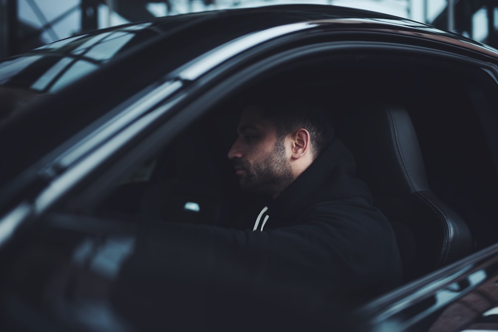 man in black hoodie inside car