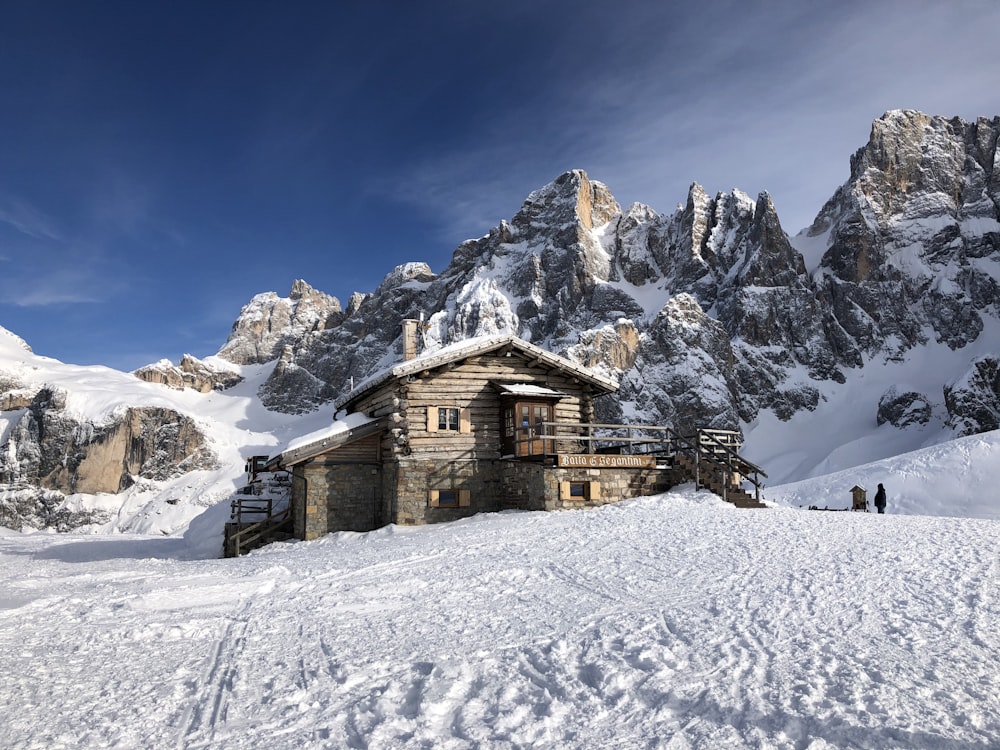 Casa de madera marrón en suelo cubierto de nieve durante el día