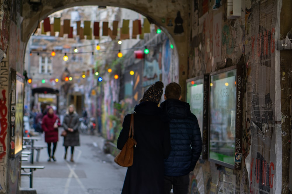 woman in black jacket walking on sidewalk during daytime