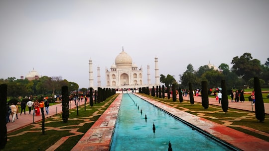 people walking on park near white concrete building during daytime in Taj Mahal Garden India