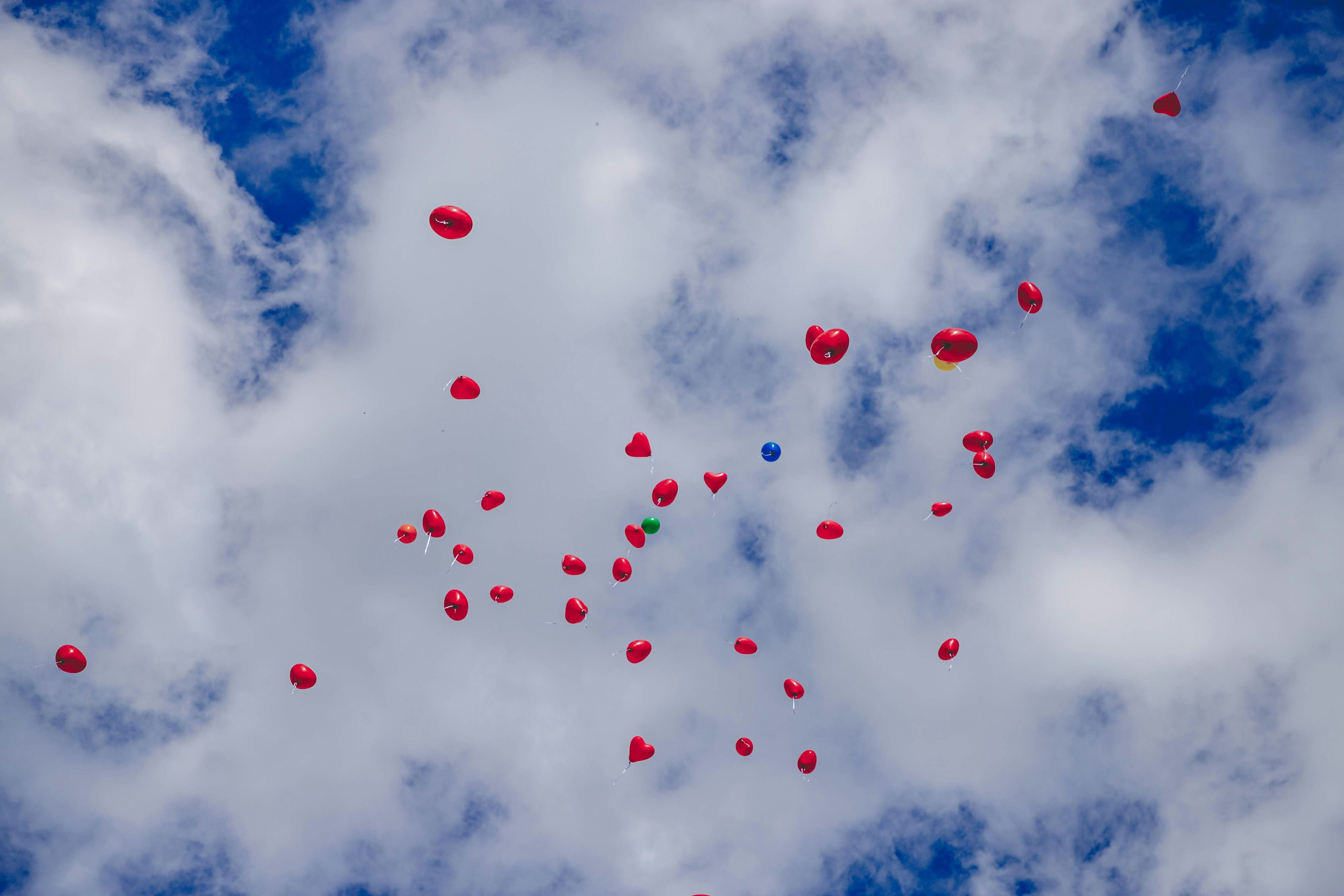 rote Luftballons tagsüber am blauen Himmel
