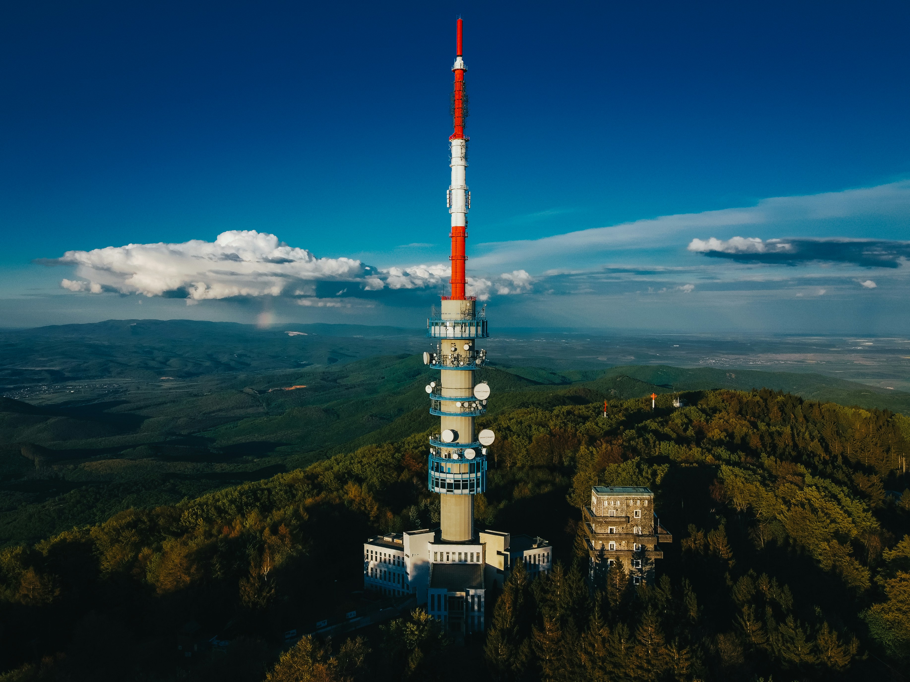 white and red tower on top of mountain under blue sky during daytime