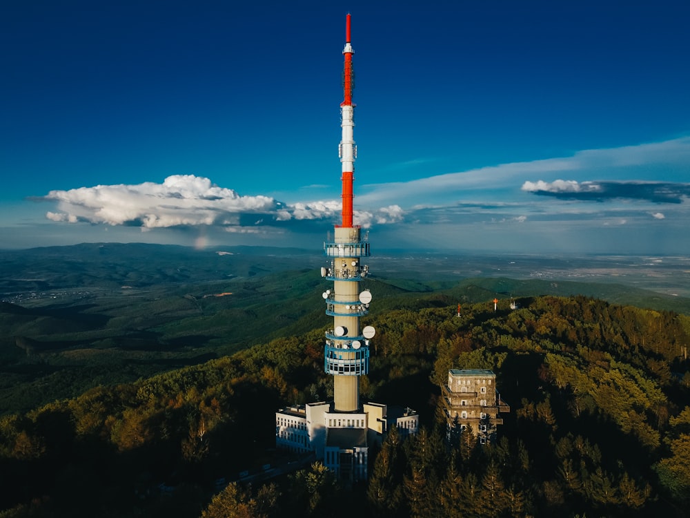 torre blanca y roja en la cima de la montaña bajo el cielo azul durante el día