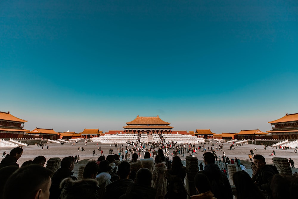 people standing near brown building during sunset