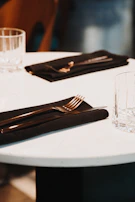 A beautifully set dining table with stainless steel dinner sets and serving accessories.