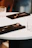 A sleek premium cutlery set displayed on a black and gold accented dining table.