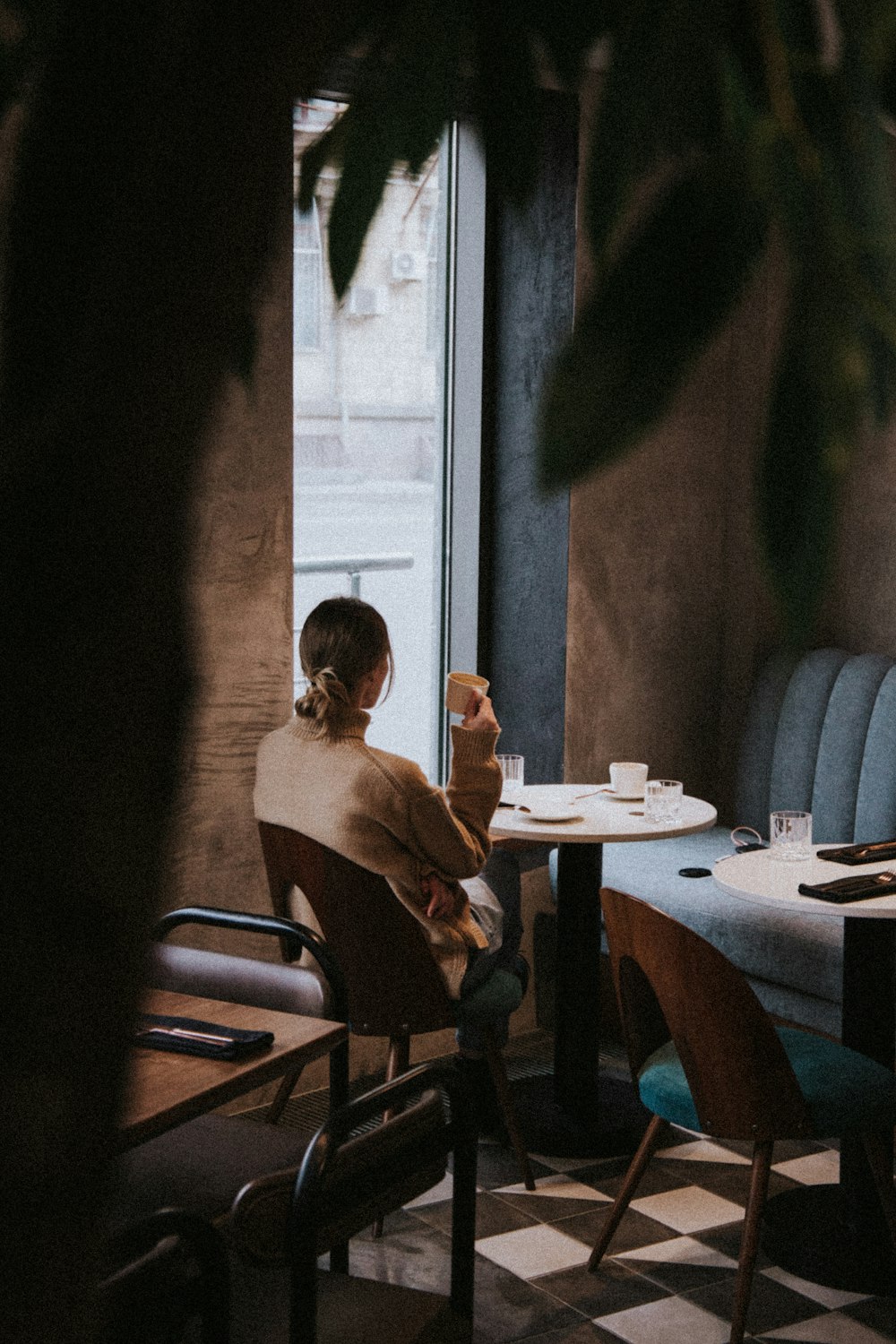 woman in red tank top sitting on chair in front of table