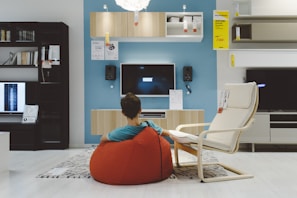 man in orange shirt sitting on white chair