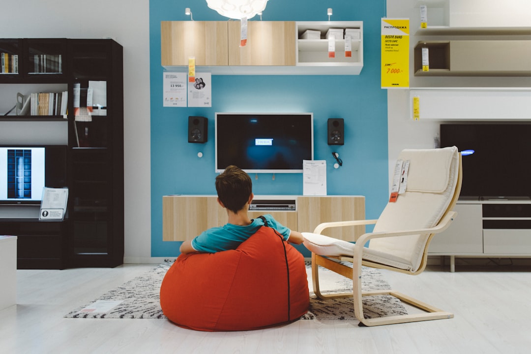 man in orange shirt sitting on white chair