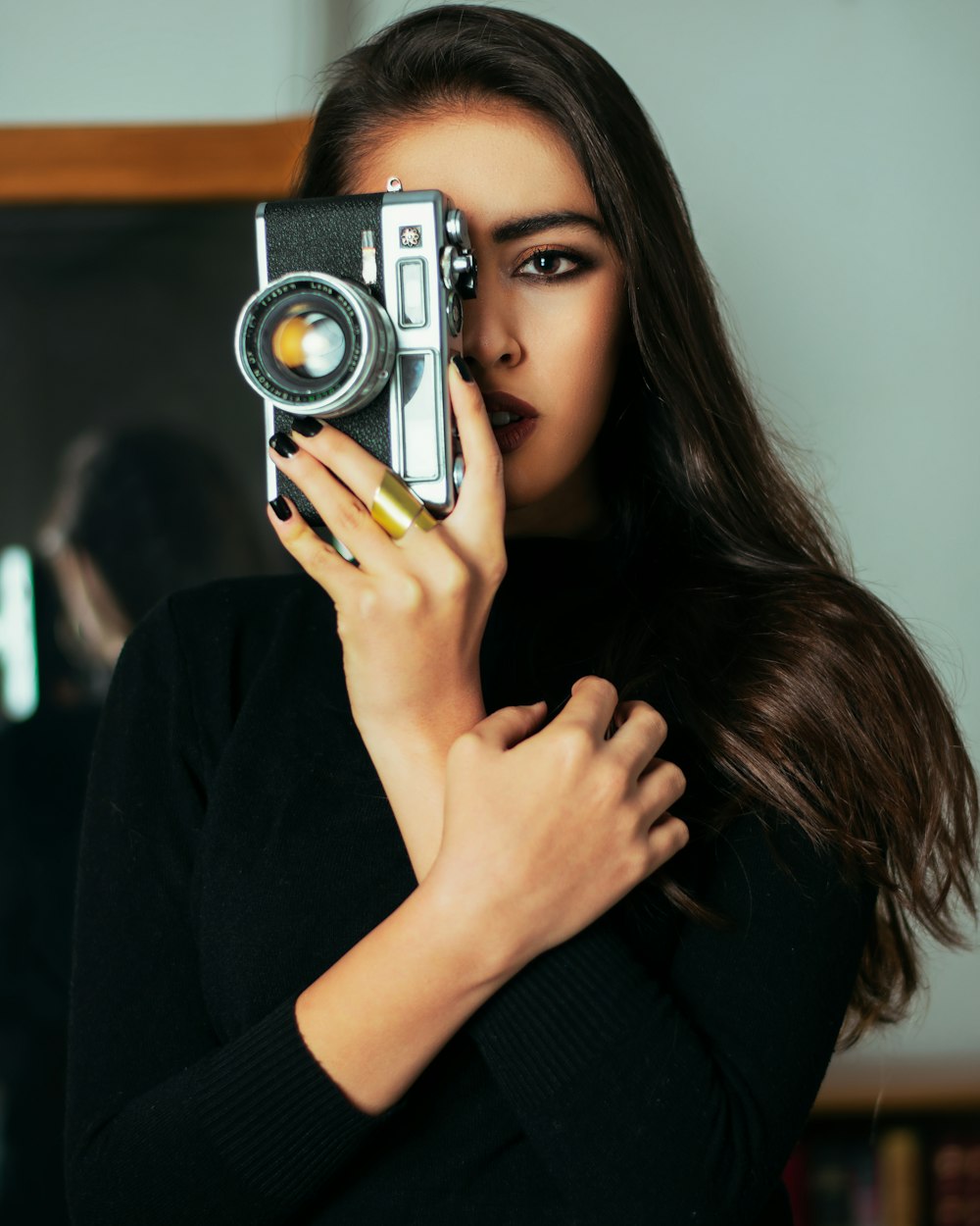 woman in black long sleeve shirt holding gray and black camera
