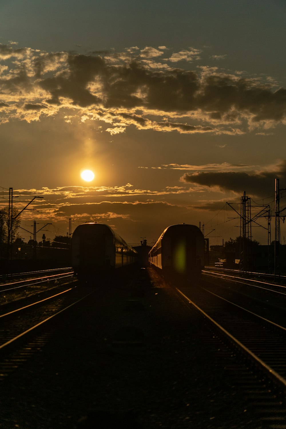 silhouette of train on rail during sunset