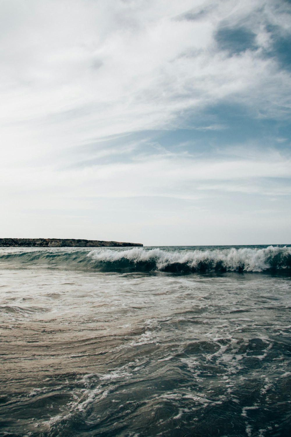 ocean waves under cloudy sky during daytime