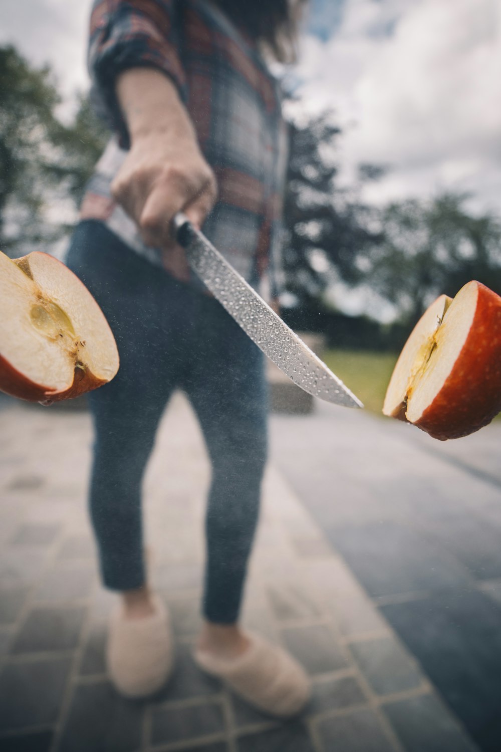 person holding knife slicing apple fruit