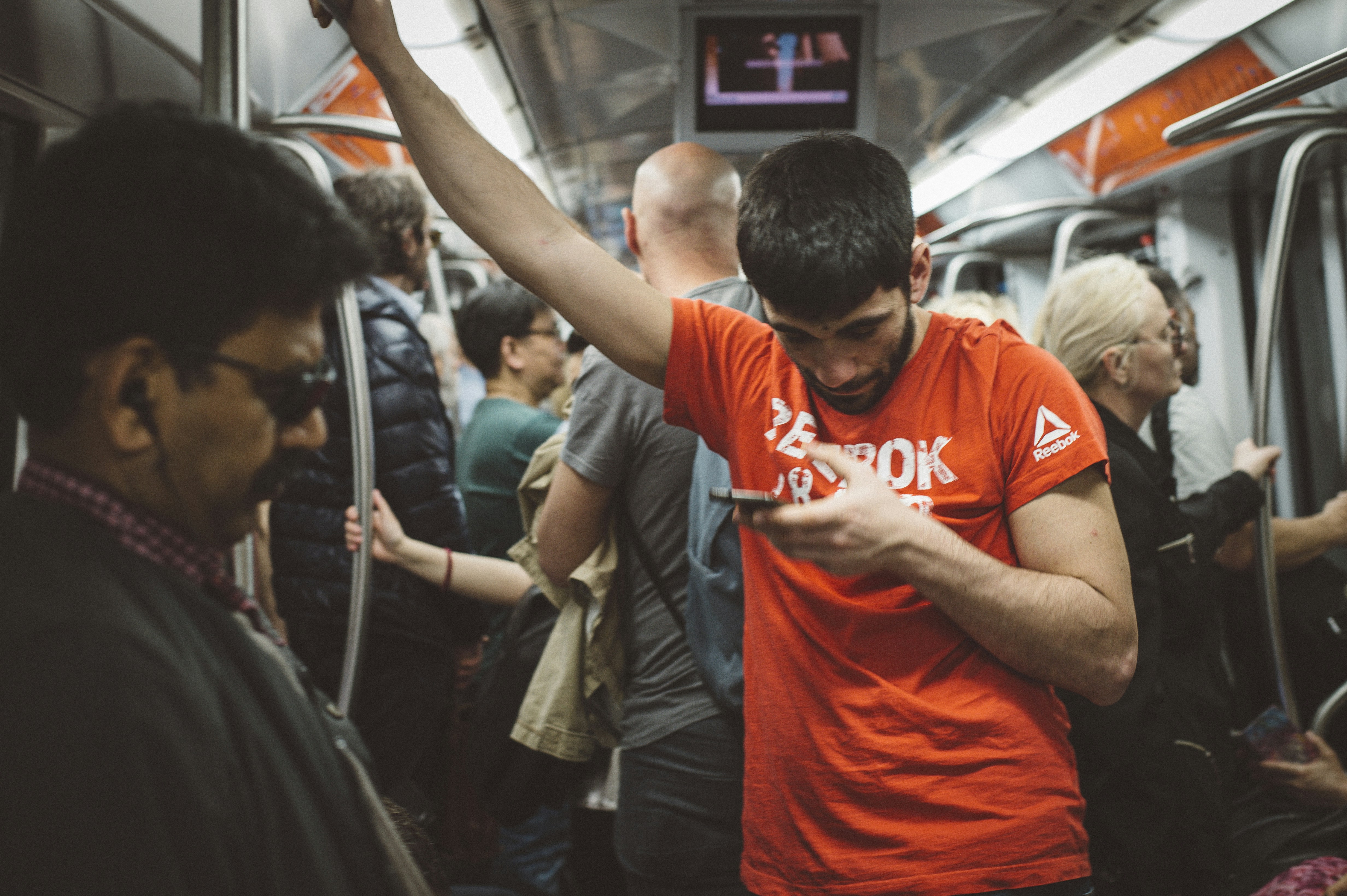 man in orange and white nike crew neck t-shirt, Metro coach passengers in Rome, Italy.