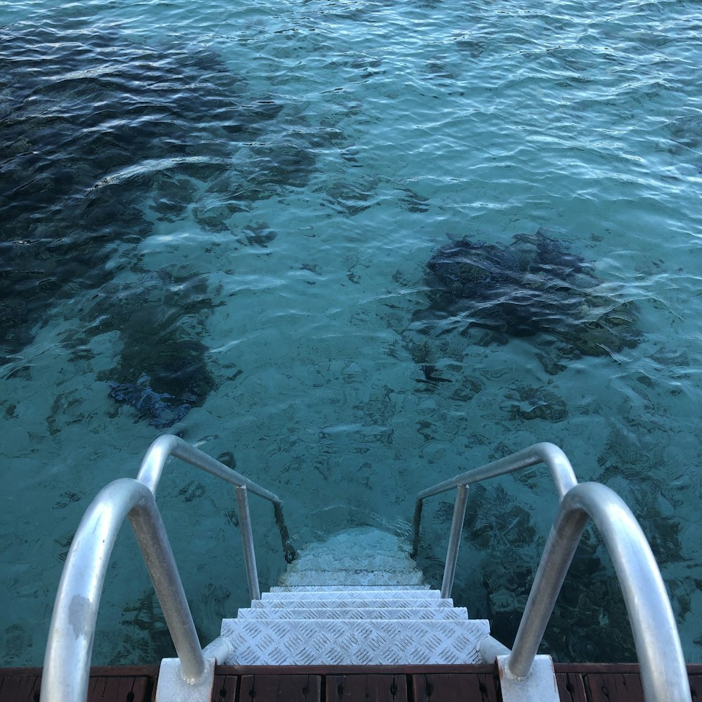 white metal railings on body of water during daytime