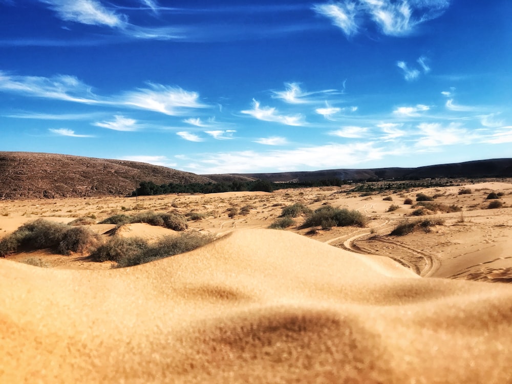 brown sand under blue sky and white clouds during daytime