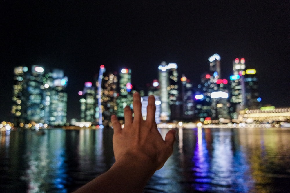 persons left hand with city lights during night time