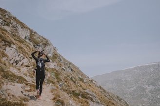 A scenic mountain trail with a hiker wearing tech gear, capturing adventure and tech blend.