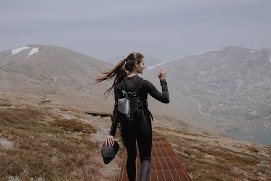 woman in black leather jacket standing on brown wooden dock during daytime in Kosciuszko National Park NSW Australia