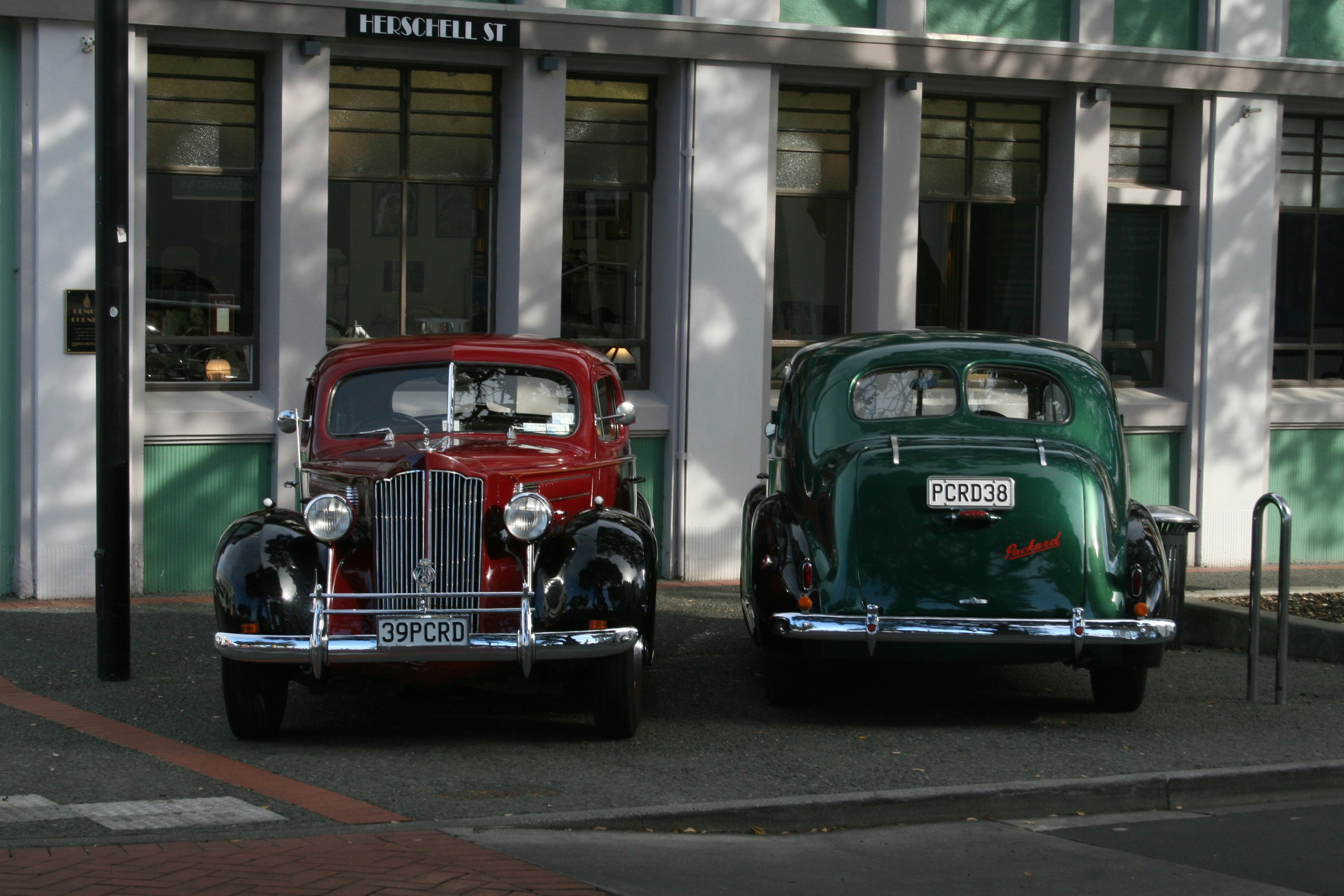 vintage green and red car parked on the street